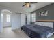 Modern bedroom with a large bed, barn door closet, and neutral color palette at 2367 W Dusty Wren Dr, Phoenix, AZ 85085