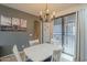 Bright dining room features an elegant chandelier, a white table, and access to the outdoor area at 2367 W Dusty Wren Dr, Phoenix, AZ 85085