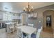 Cozy dining area features a chandelier, white table and chairs, and seamless access to the kitchen at 2367 W Dusty Wren Dr, Phoenix, AZ 85085