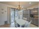Dining area complete with seating and a chandelier, bathed in natural light from the outdoor access at 2367 W Dusty Wren Dr, Phoenix, AZ 85085