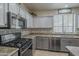 Well-lit kitchen featuring stainless steel appliances, gray cabinets, and contemporary countertops at 2367 W Dusty Wren Dr, Phoenix, AZ 85085