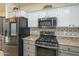 A stylish kitchen featuring stainless steel appliances, a gas range, and a decorative tile backsplash at 2367 W Dusty Wren Dr, Phoenix, AZ 85085