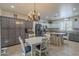 Bright kitchen with stainless steel appliances, two-tone cabinets, and a dining area with a vintage chandelier at 2367 W Dusty Wren Dr, Phoenix, AZ 85085