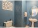 Stylish powder room with blue patterned walls, pedestal sink, and decorative mirror at 2367 W Dusty Wren Dr, Phoenix, AZ 85085
