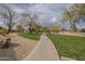 A paved walking path meanders through the community park, surrounded by desert landscaping at 2367 W Dusty Wren Dr, Phoenix, AZ 85085