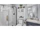 Modern bathroom with a glass shower door, white cabinetry and decorative elements at 2505 E Hampton Ave, Mesa, AZ 85204