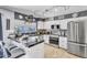 Well-lit kitchen with white cabinets, black countertops, and stainless steel appliances at 2505 E Hampton Ave, Mesa, AZ 85204