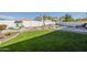 Beautiful backyard featuring a well-manicured lawn, a rock waterfall pool, and a charming playhouse at 2506 E Bridgeport Pkwy, Gilbert, AZ 85295