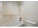 Bathtub with shower features a sleek showerhead in an all-white bathroom at 2506 E Bridgeport Pkwy, Gilbert, AZ 85295
