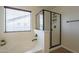 Bright bathroom featuring a soaking tub, glass-enclosed shower, and a window for natural light at 2506 E Bridgeport Pkwy, Gilbert, AZ 85295