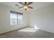 Comfortable bedroom with neutral carpet, ceiling fan, and natural light from a large window at 2506 E Bridgeport Pkwy, Gilbert, AZ 85295