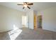 Bright bedroom featuring a ceiling fan, carpeted floors, and multiple doors at 2506 E Bridgeport Pkwy, Gilbert, AZ 85295