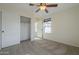 Bright bedroom features plush carpeting, a ceiling fan, and a spacious closet for ample storage at 2506 E Bridgeport Pkwy, Gilbert, AZ 85295