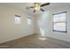 Well-lit bedroom with three windows, plush carpet, and a ceiling fan for added comfort at 2506 E Bridgeport Pkwy, Gilbert, AZ 85295