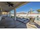 Covered patio overlooks a backyard pool area featuring a waterfall and desert landscaping at 2506 E Bridgeport Pkwy, Gilbert, AZ 85295