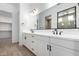 Bathroom vanity with double sinks, white cabinets and black hardware at 25393 N 158Th Ct, Surprise, AZ 85387