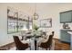 Bright dining room with a glass-top table set for six and a large window with a view of the backyard at 2730 W Via Calabria St, Phoenix, AZ 85086