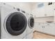 Bright laundry room featuring front loading washer and dryer and plentiful white storage cabinets at 2777 W Queen Creek Rd # 9, Chandler, AZ 85248