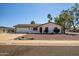Charming single-story home featuring a two-car garage, red front door, and a well-manicured front yard at 2801 E Sylvia St, Phoenix, AZ 85032
