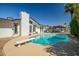 Backyard pool featuring a diving board, mature landscaping, and an exterior elevation at 2801 E Sylvia St, Phoenix, AZ 85032