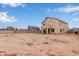 View of home's back exterior featuring large backyard, patio, and well-maintained stucco at 2834 N Paisley Ln, Casa Grande, AZ 85122