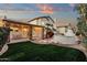 Backyard featuring a covered patio, fireplace, lush greenery, and a well-manicured lawn at 3037 E Bighorn Ave, Phoenix, AZ 85048