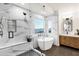 Modern bathroom with a soaking tub, glass shower with a bench, and marble countertops at 3037 E Bighorn Ave, Phoenix, AZ 85048