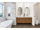 Modern bathroom with double sinks, wood cabinets, and a window offering natural light at 3037 E Bighorn Ave, Phoenix, AZ 85048