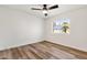 Cozy bedroom with wood floors, ceiling fan, and a bright window with a view of palm trees at 3037 E Bighorn Ave, Phoenix, AZ 85048