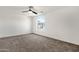 Spacious bedroom with neutral carpet, a modern ceiling fan, and a large arched window at 3037 E Bighorn Ave, Phoenix, AZ 85048