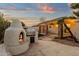 Outdoor fireplace and grill area, with a covered patio area and a view of the landscaped yard at 3037 E Bighorn Ave, Phoenix, AZ 85048