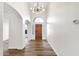 Bright foyer features wood flooring, arched doorways, modern chandelier, and a front door view at 3037 E Bighorn Ave, Phoenix, AZ 85048