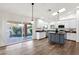 Modern kitchen with a large center island, stainless steel appliances, and sliding glass doors to the backyard at 3037 E Bighorn Ave, Phoenix, AZ 85048