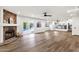 Open living room featuring a stone fireplace, wood floors, recessed lighting, and view into the kitchen at 3037 E Bighorn Ave, Phoenix, AZ 85048