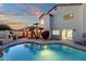 Backyard pool area featuring an outdoor kitchen, covered patio, and landscaped yard at dusk at 3037 E Bighorn Ave, Phoenix, AZ 85048