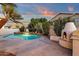 Backyard with a tranquil pool featuring a stone waterfall feature next to a gas fireplace and seating at 3037 E Bighorn Ave, Phoenix, AZ 85048