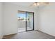 The bedroom features a sliding glass door with patio views, carpeting, and neutral paint at 3301 E Earll Dr # 210, Phoenix, AZ 85018