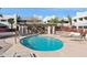Community pool and hot tub area with lounge chairs and a covered seating area surrounded by condominium buildings at 3301 E Earll Dr # 210, Phoenix, AZ 85018