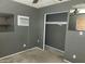 A gray bedroom featuring closet, window AC unit, and mirrored decor at 3618 W Las Palmaritas Dr, Phoenix, AZ 85051