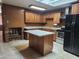 A kitchen is enhanced by wood cabinets, stone countertops, a kitchen island and a brick fireplace at 3618 W Las Palmaritas Dr, Phoenix, AZ 85051