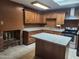 A kitchen is enhanced by wood cabinets, stone countertops, a kitchen island and a brick fireplace at 3618 W Las Palmaritas Dr, Phoenix, AZ 85051