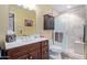 Well-lit bathroom featuring a walk-in shower, a dark wood vanity, and a medicine cabinet at 36801 N Long Rifle Rd, Carefree, AZ 85377