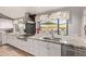 Stylish kitchen with a stainless steel range, granite countertops, and white cabinets at 36801 N Long Rifle Rd, Carefree, AZ 85377