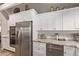 Modern kitchen featuring stainless steel refrigerator, white cabinetry, and granite counters at 36801 N Long Rifle Rd, Carefree, AZ 85377