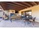 Inviting covered patio features a stone fireplace, ceiling fan, and comfortable seating area at 36801 N Long Rifle Rd, Carefree, AZ 85377
