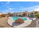 Beautiful backyard pool with a rock feature, lounge chairs, and a covered dining area at 3689 N Crane Pl, Casa Grande, AZ 85122