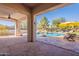 Beautiful covered patio with ceiling fan, overlooking a stunning pool with rock waterfall feature at 3820 E Carson Rd, Phoenix, AZ 85042