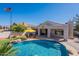 Backyard oasis features a rock pool with a covered patio, outdoor kitchen, and lounge area at 3820 E Carson Rd, Phoenix, AZ 85042