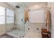 Bright, marble-clad walk-in shower featuring glass enclosure and window at 3825 E Irwin Ave, Mesa, AZ 85206