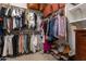 Organized walk-in closet featuring hanging clothes, shoe racks, and storage boxes at 3825 E Irwin Ave, Mesa, AZ 85206